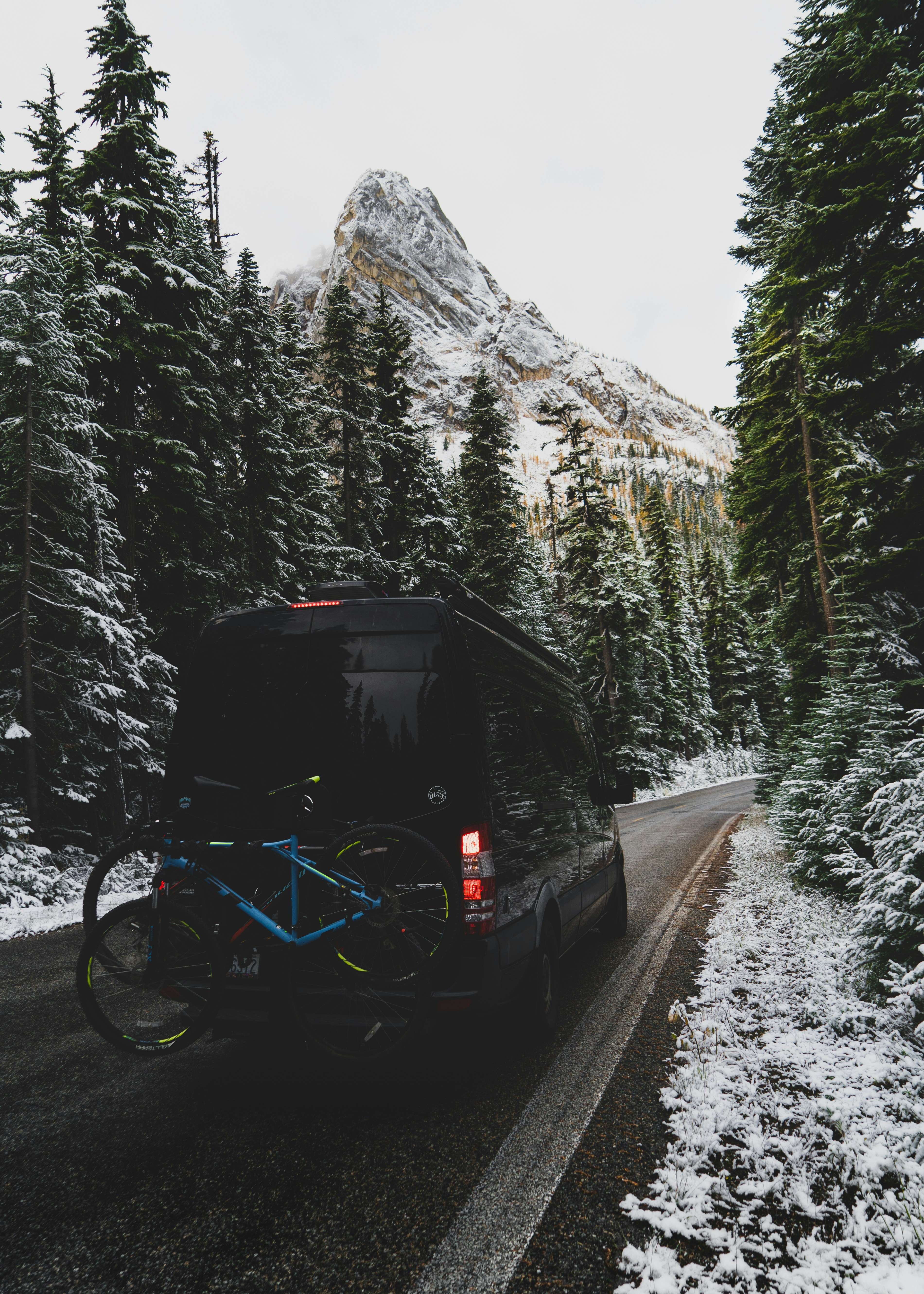 낮 동안 회색 아스팔트 도로에서 검은 색과 파란색 자전거