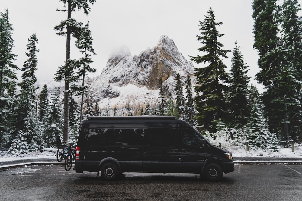 black suv parked near green trees and mountain during daytime