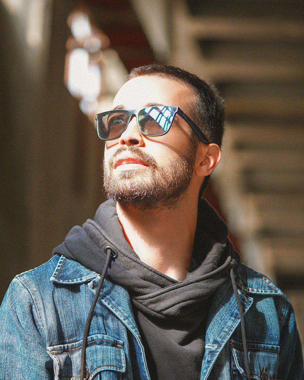 man in blue denim jacket wearing black sunglasses