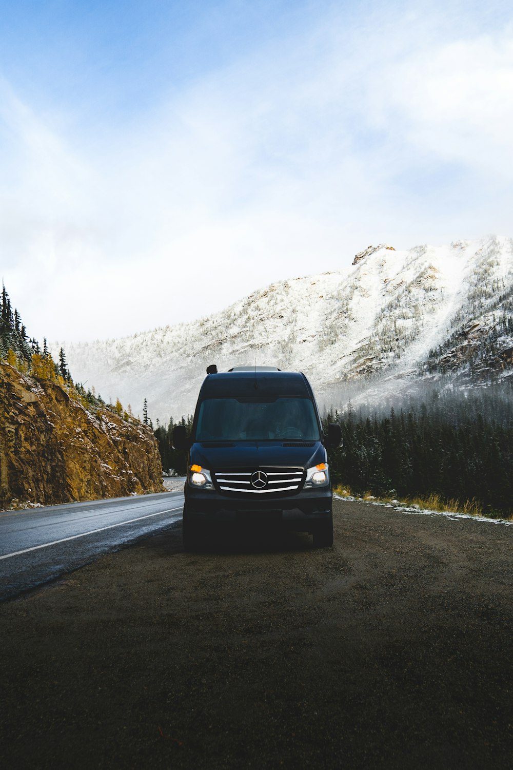 black car on road near snow covered mountain during daytime