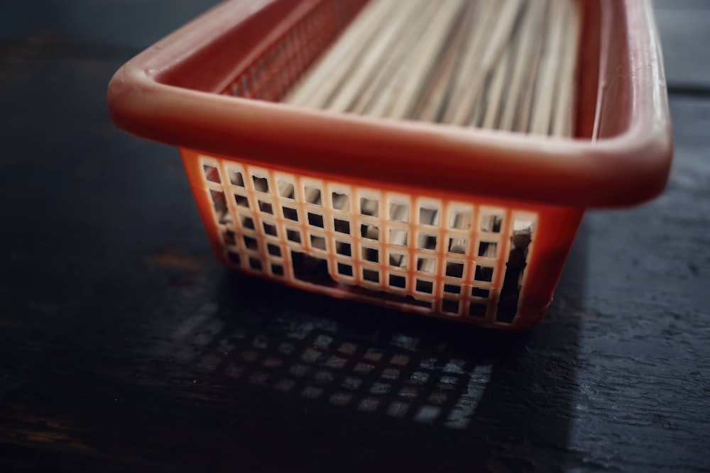 white sticks in orange plastic basket