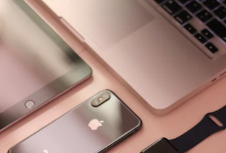 A collection of sleek, modern electronic devices including a laptop, smartphone, tablet, smartwatch, and wireless mouse, all featuring a consistent design theme with a focus on minimalism and elegance.