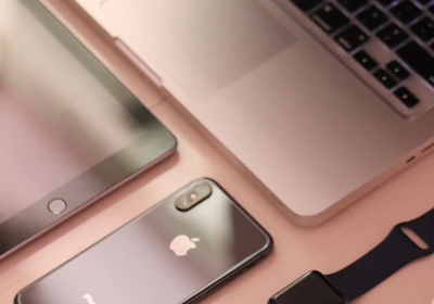 A collection of sleek, modern electronic devices including a laptop, smartphone, tablet, smartwatch, and wireless mouse, all featuring a consistent design theme with a focus on minimalism and elegance.