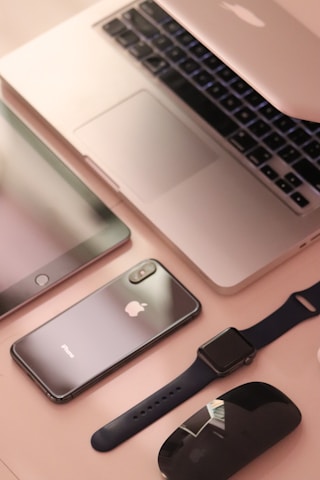 A collection of sleek, modern electronic devices including a laptop, smartphone, tablet, smartwatch, and wireless mouse, all featuring a consistent design theme with a focus on minimalism and elegance.