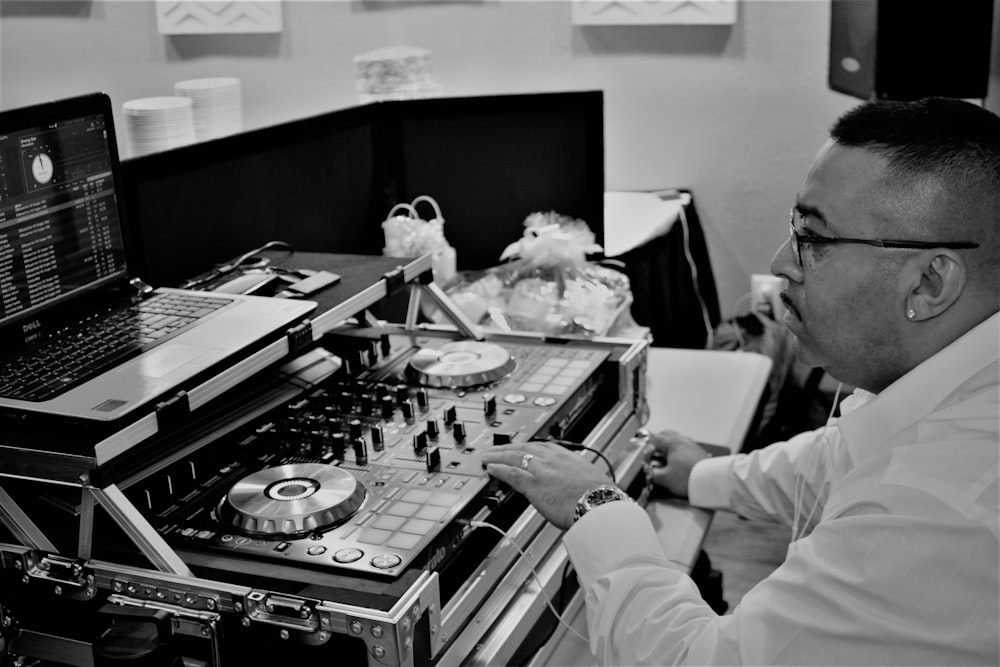 man in white dress shirt playing dj controller