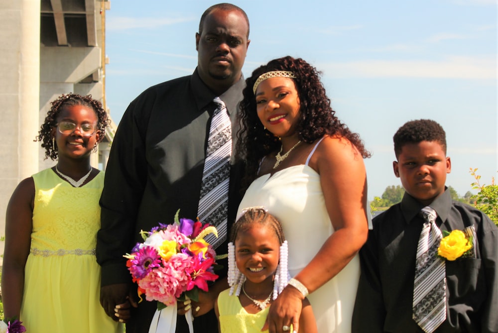 man in black suit jacket beside woman in white sleeveless dress