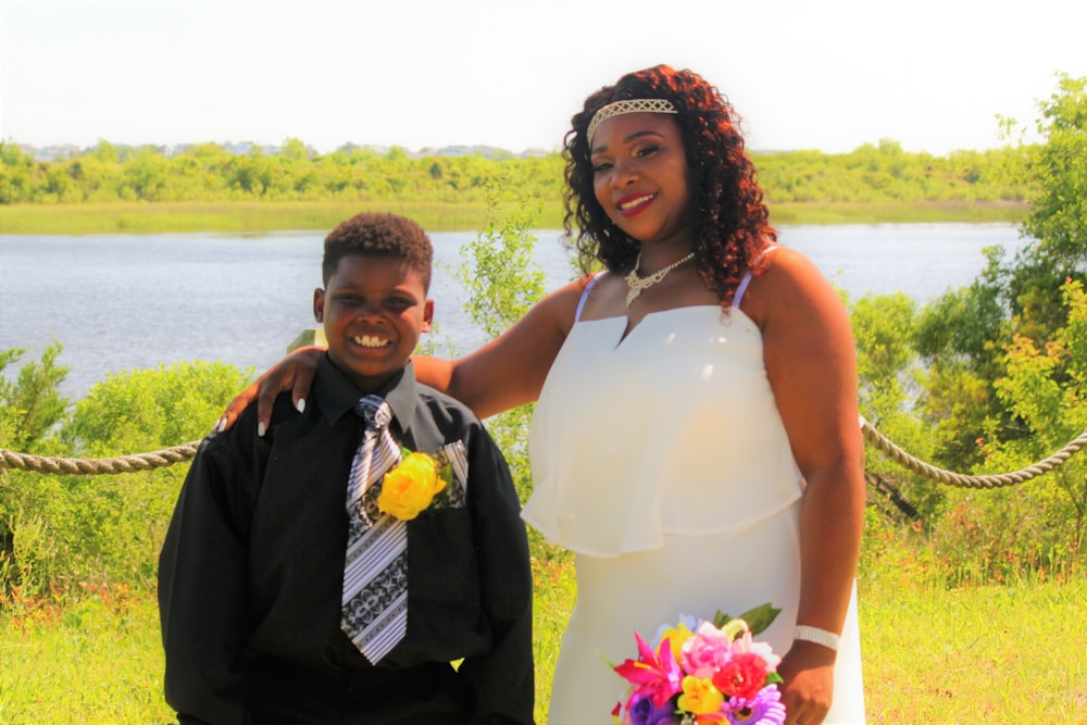 man in black suit jacket beside woman in white sleeveless dress