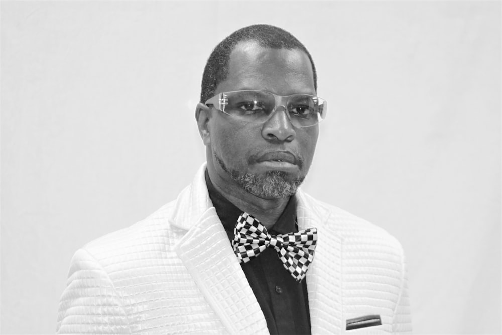 man in white suit wearing black and white polka dot bowtie