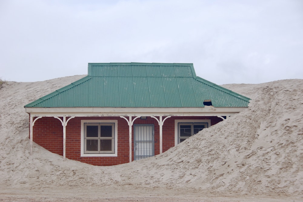 green wooden house on brown sand during daytime