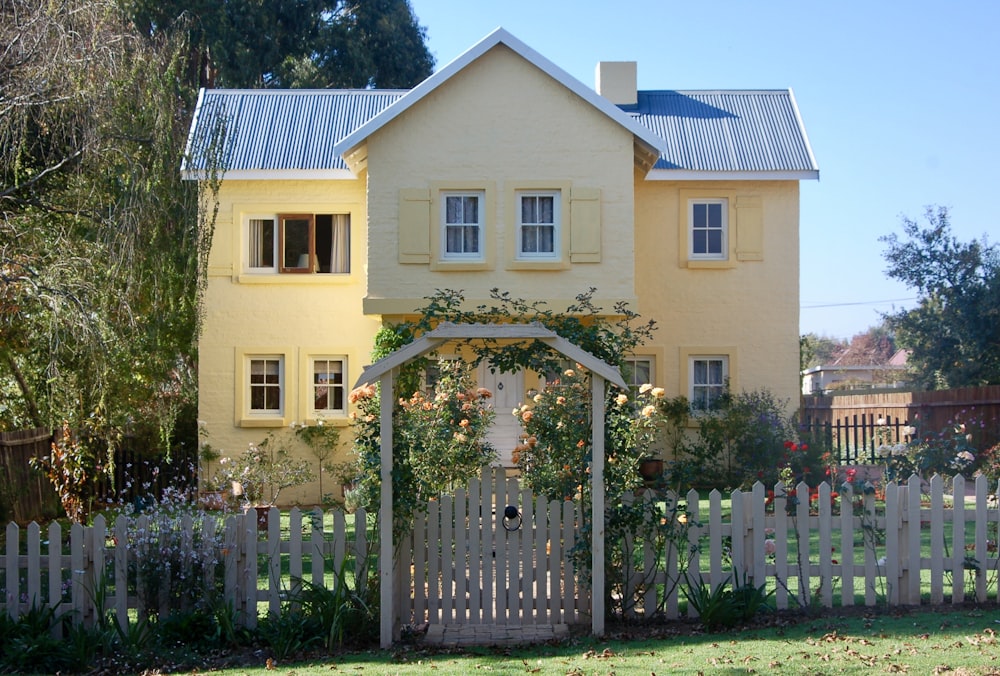 Maison en béton beige avec clôture en bois blanc