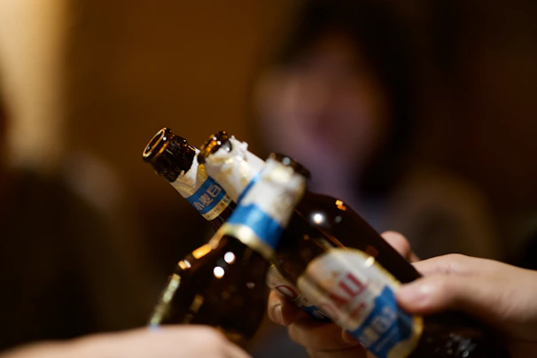 A group of friends clinking beer bottles at a lively rock concert