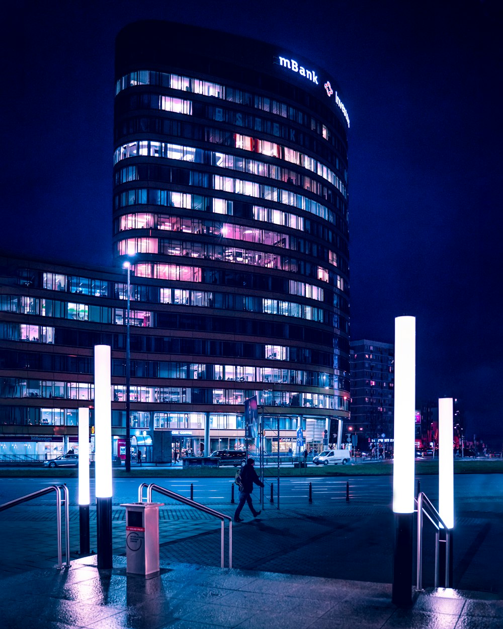 people walking on sidewalk near high rise building during nighttime