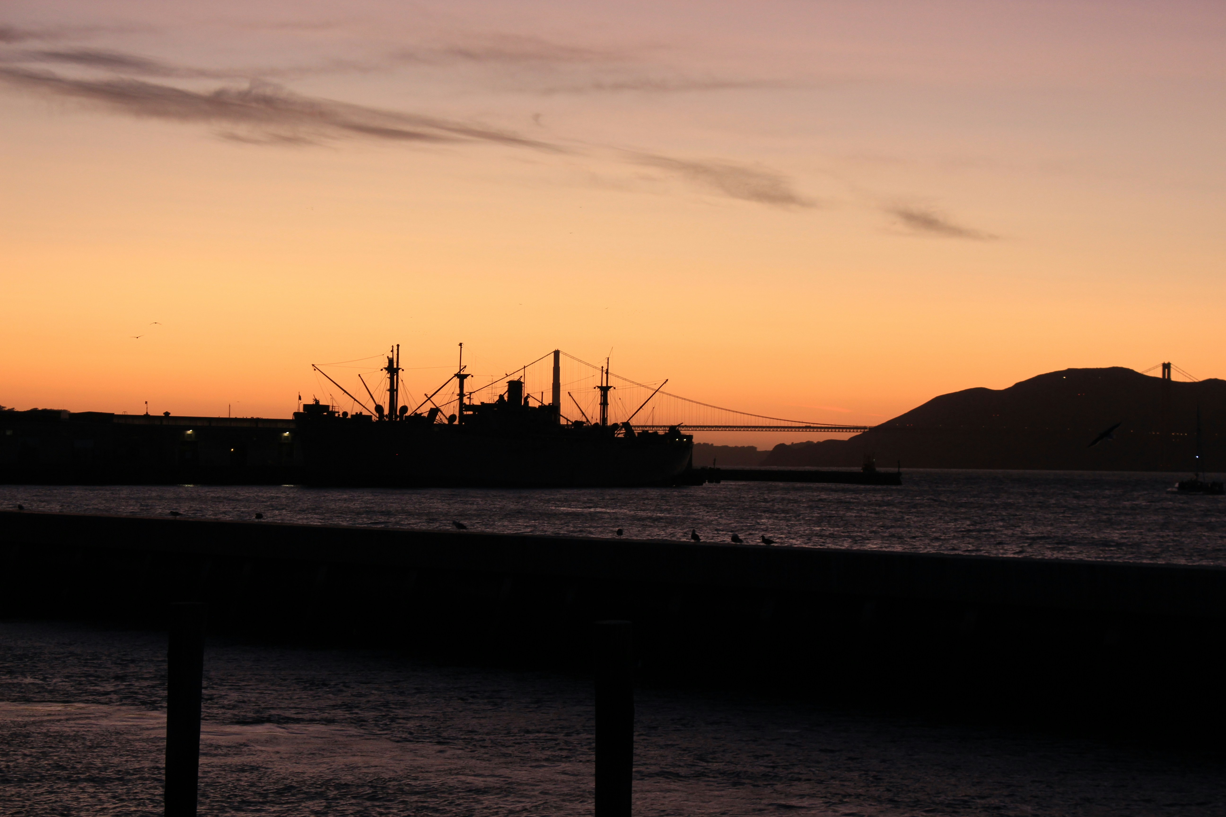 silhouette of a boat on sea during sunset