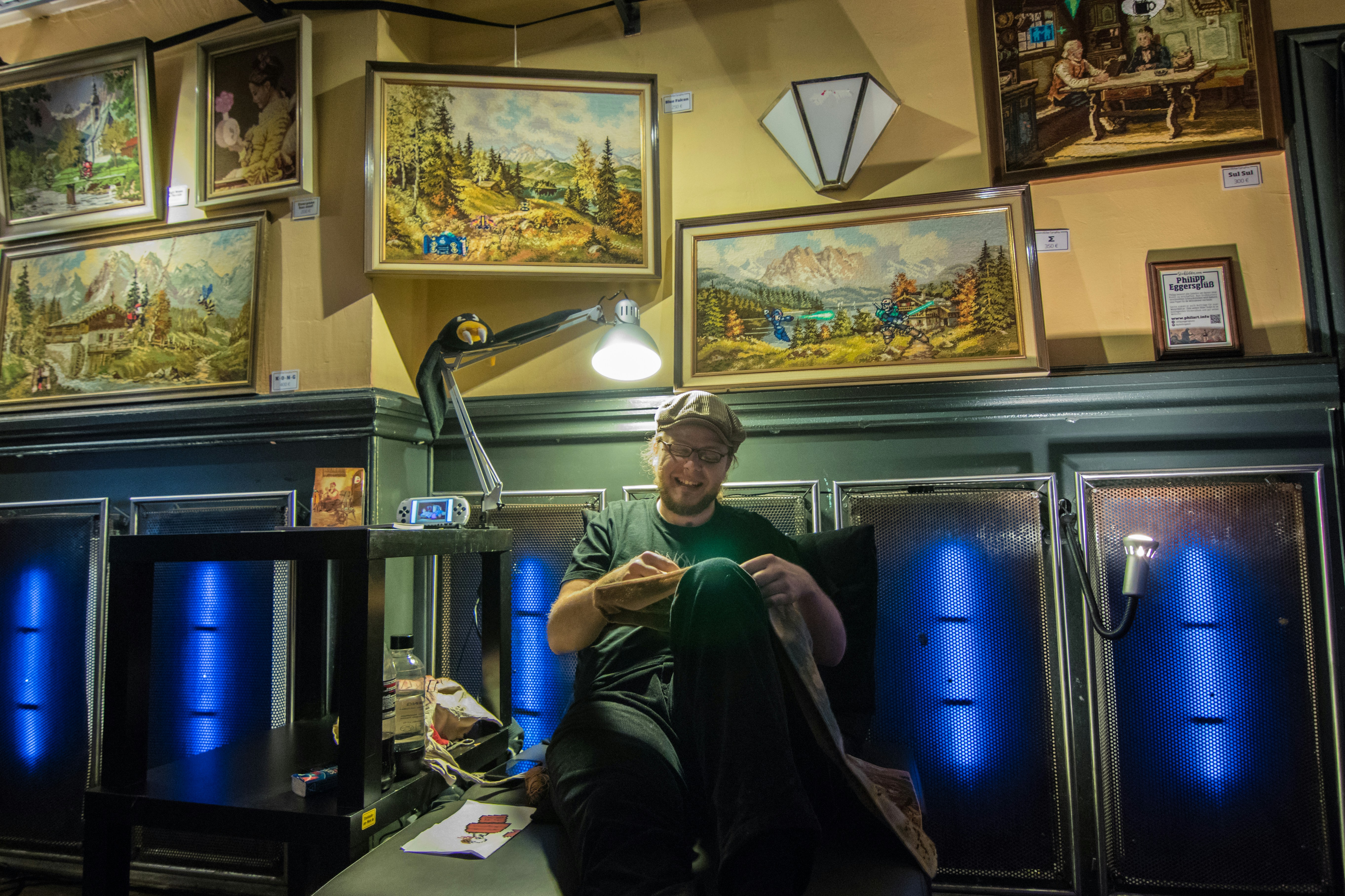 Mann in schwarz-grünem Langarmhemd sitzt auf Stuhl