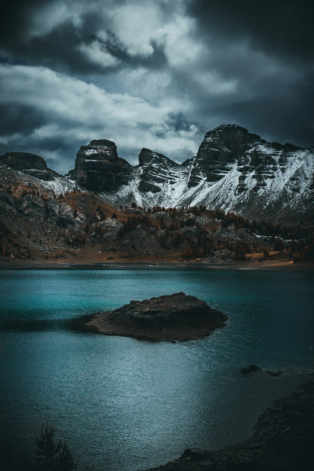 brown and white mountain near body of water during daytime