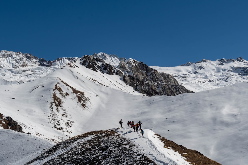 people hiking on snow covered mountain during daytime