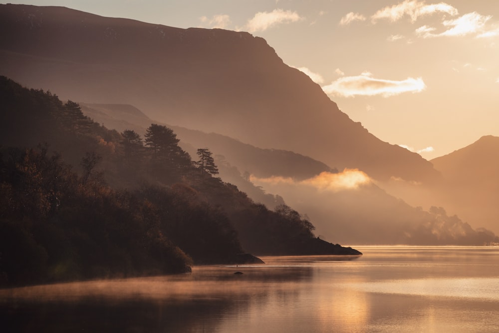 silhouette of mountain near body of water during daytime