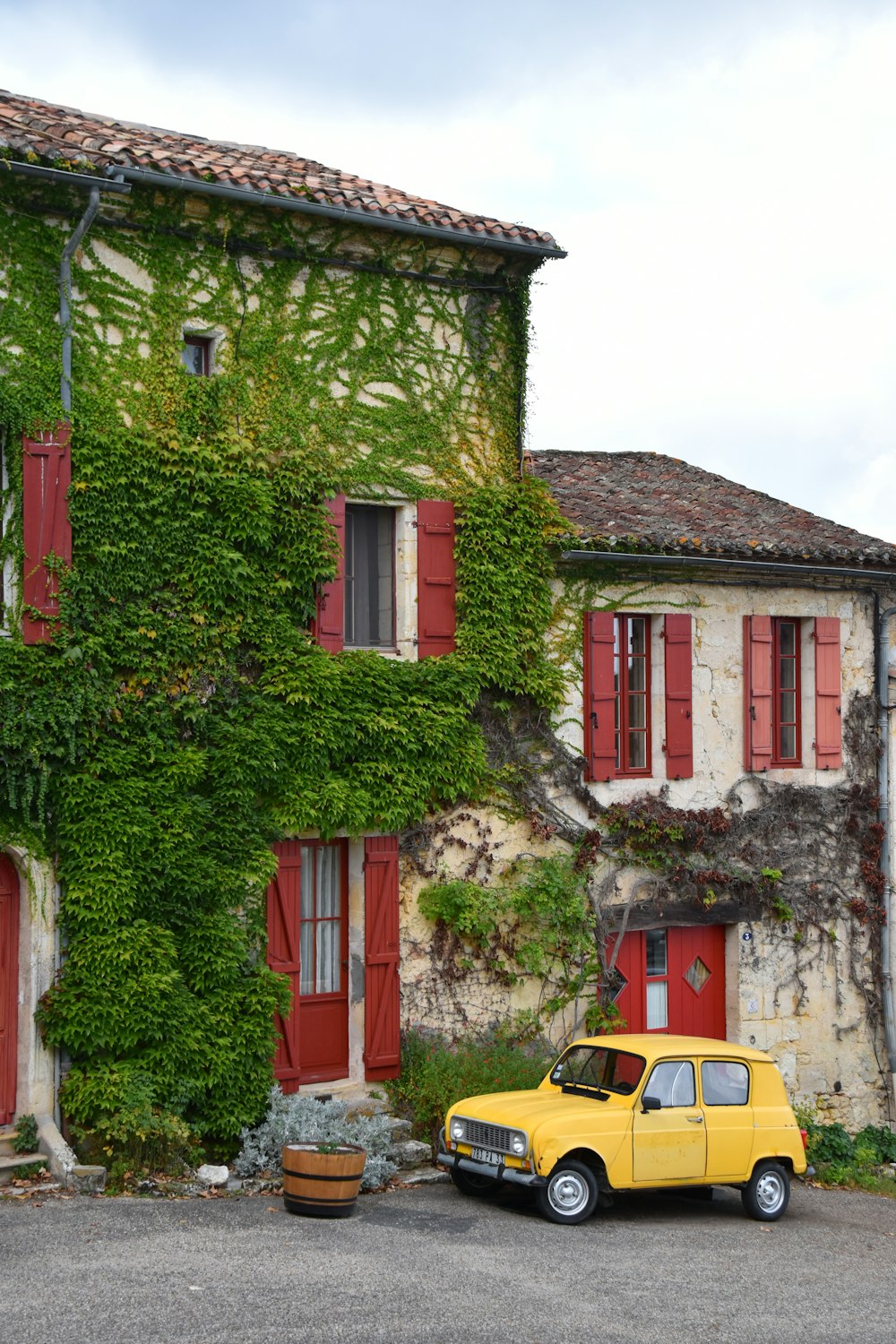 yellow car parked beside red and white concrete building
