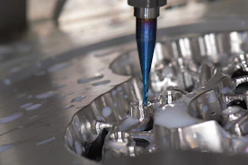 Close-up of CNC machine cutting a metal part with sparks flying.