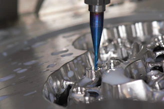 Close-up of CNC machine cutting a metal part with sparks flying.
