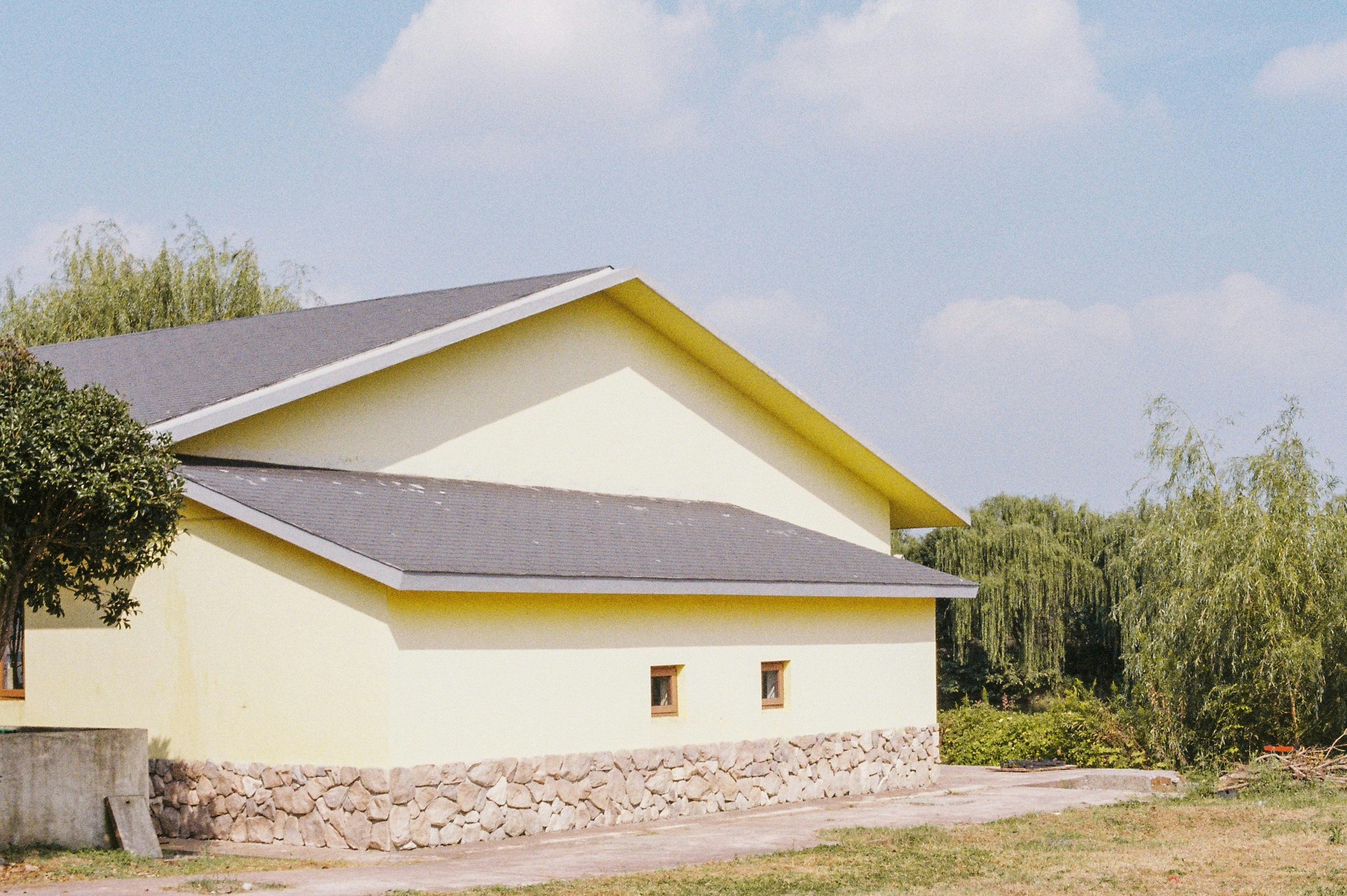 white concrete house near green trees under blue sky during daytime