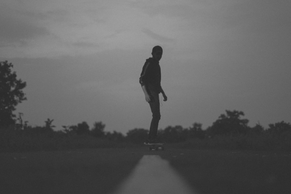 man in black jacket walking on road