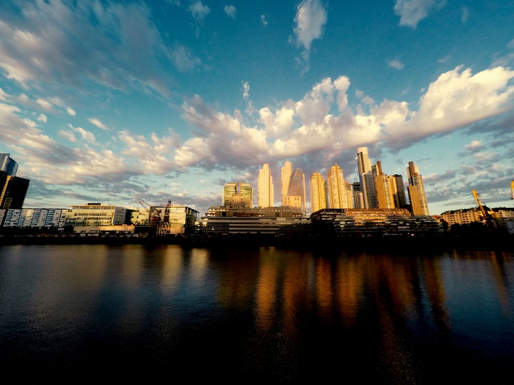 city skyline across body of water under blue and white sunny cloudy sky during daytime