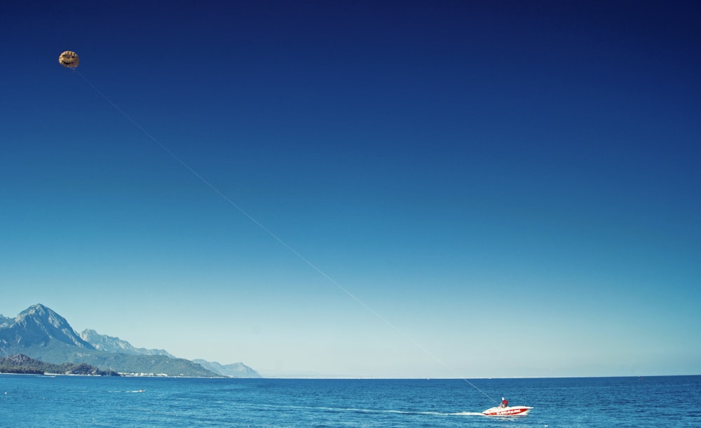 person in red kayak on sea during daytime