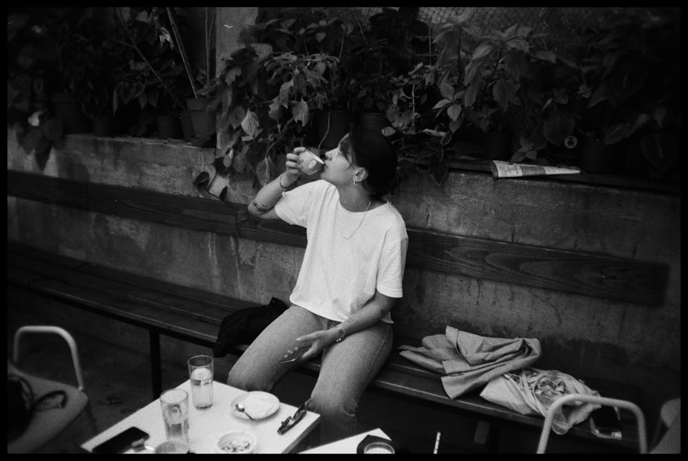 man in white crew neck t-shirt sitting on bench