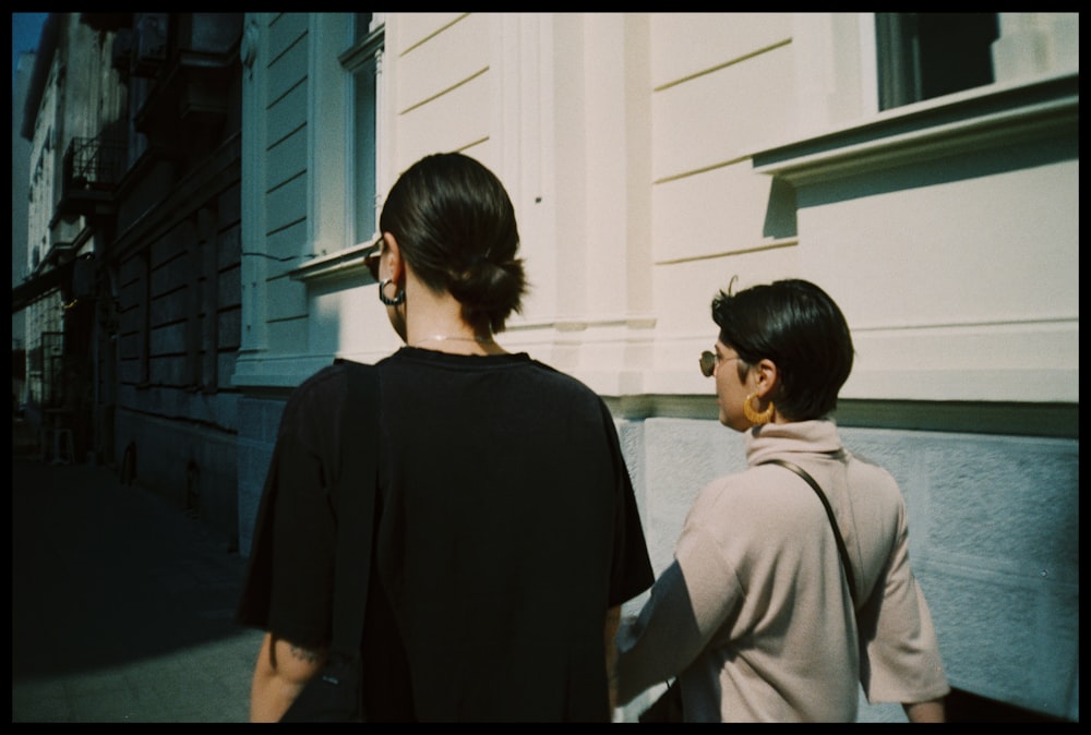 woman in black shirt standing beside man in gray coat