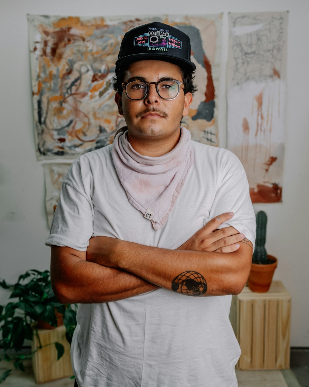 man in white crew neck t-shirt wearing black cap and black framed eyeglasses