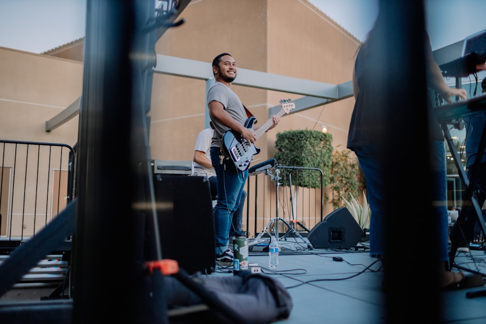 hombre con camiseta blanca sin mangas tocando la guitarra eléctrica