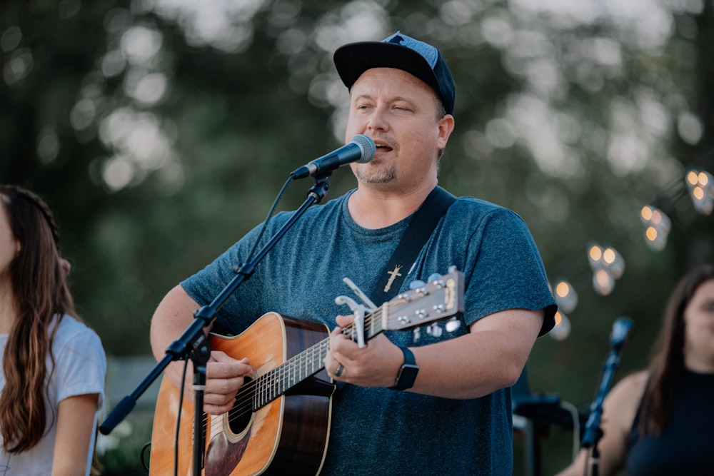 man in blue crew neck t-shirt singing