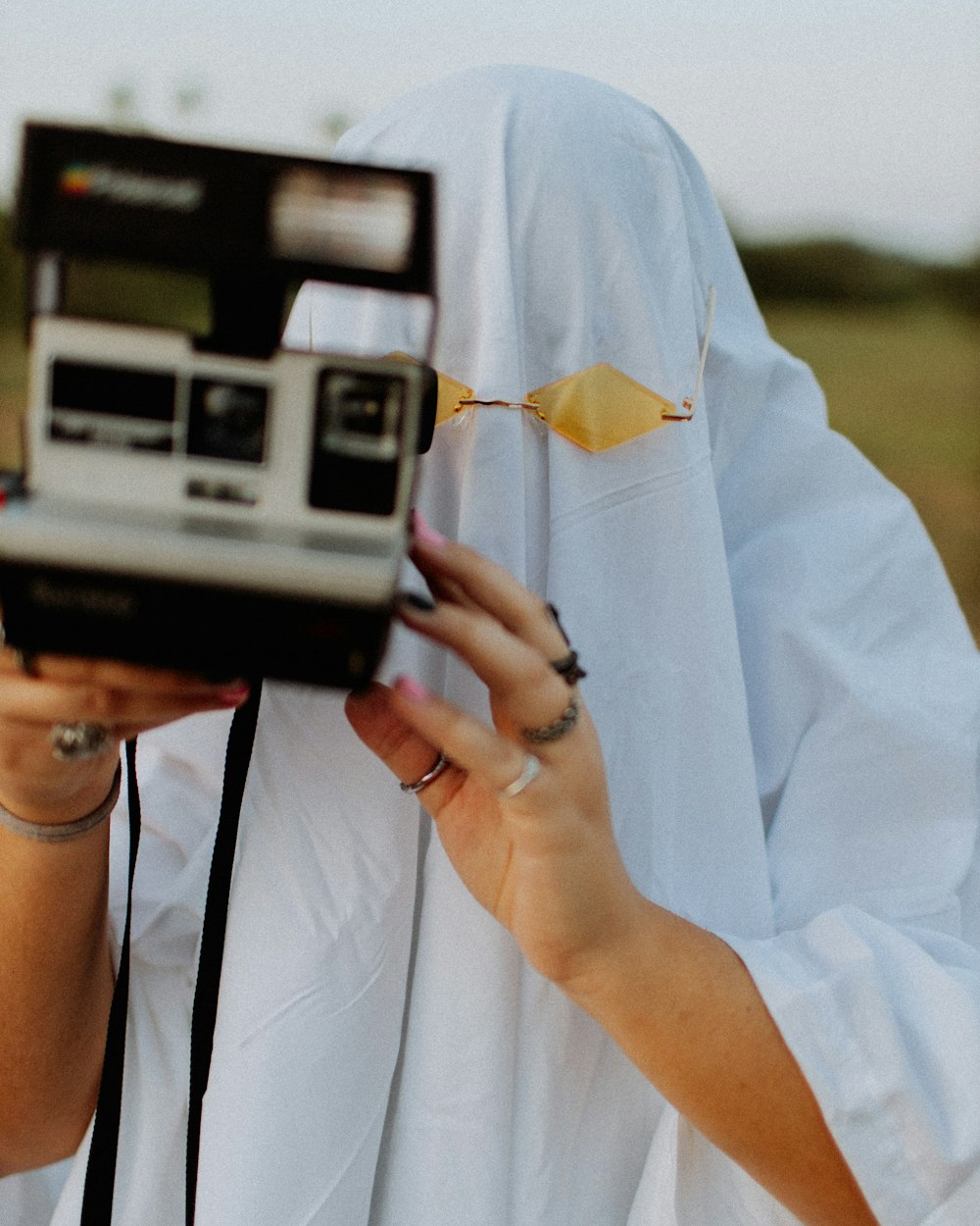 Persona sosteniendo una cámara Polaroid durante el día