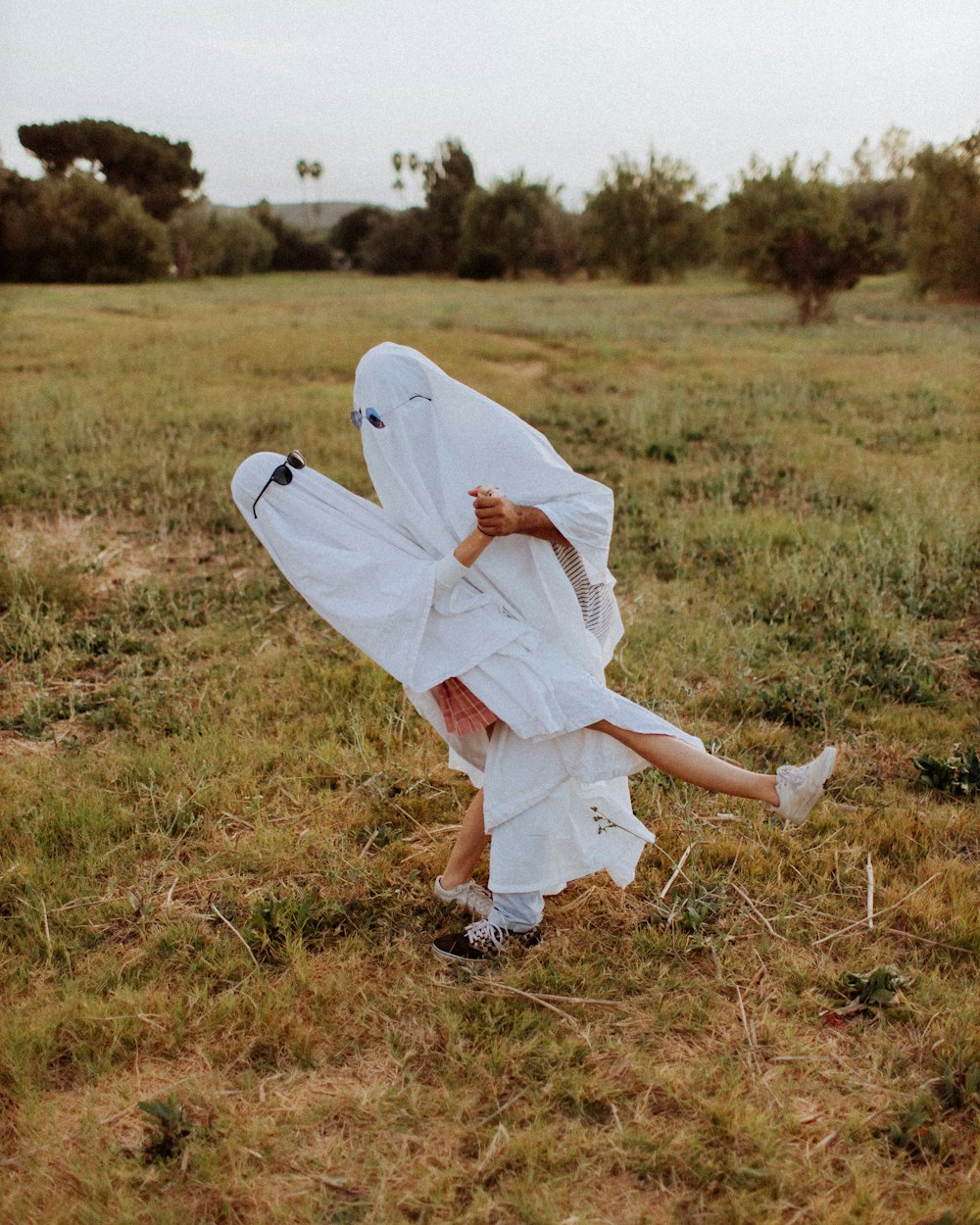 woman in white dress on brown grass field during daytime