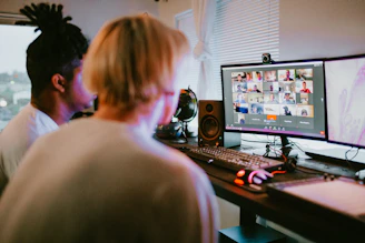 woman in white shirt sitting in front of computer