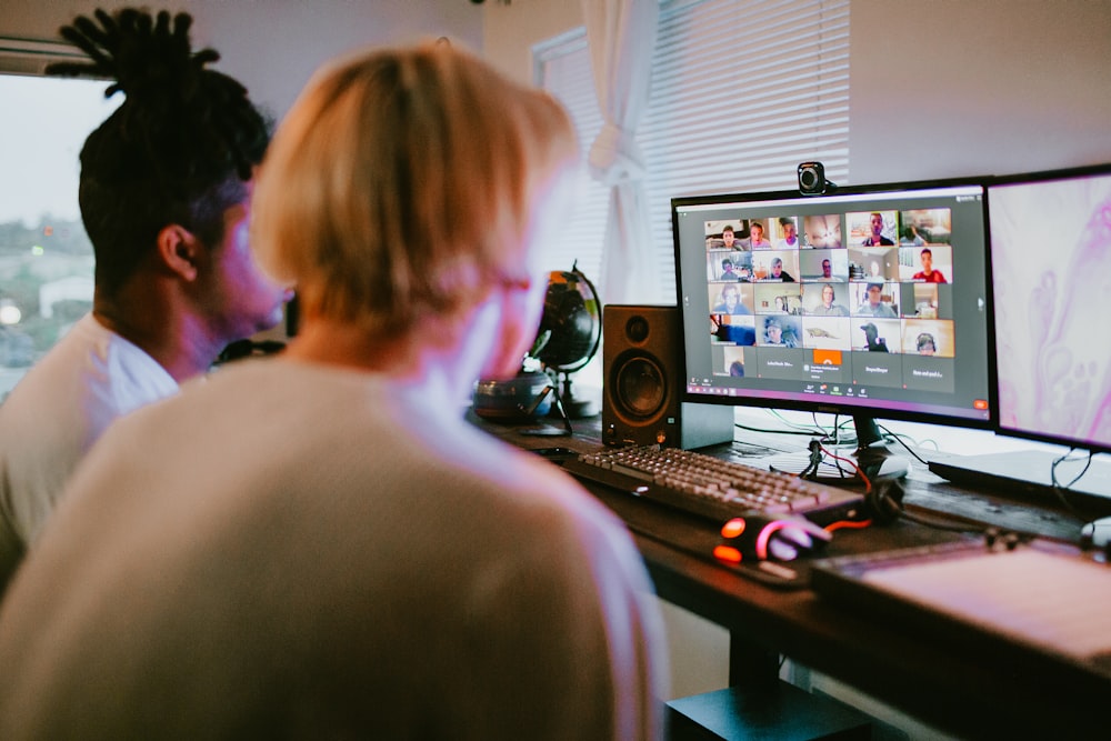 woman in white shirt sitting in front of computer