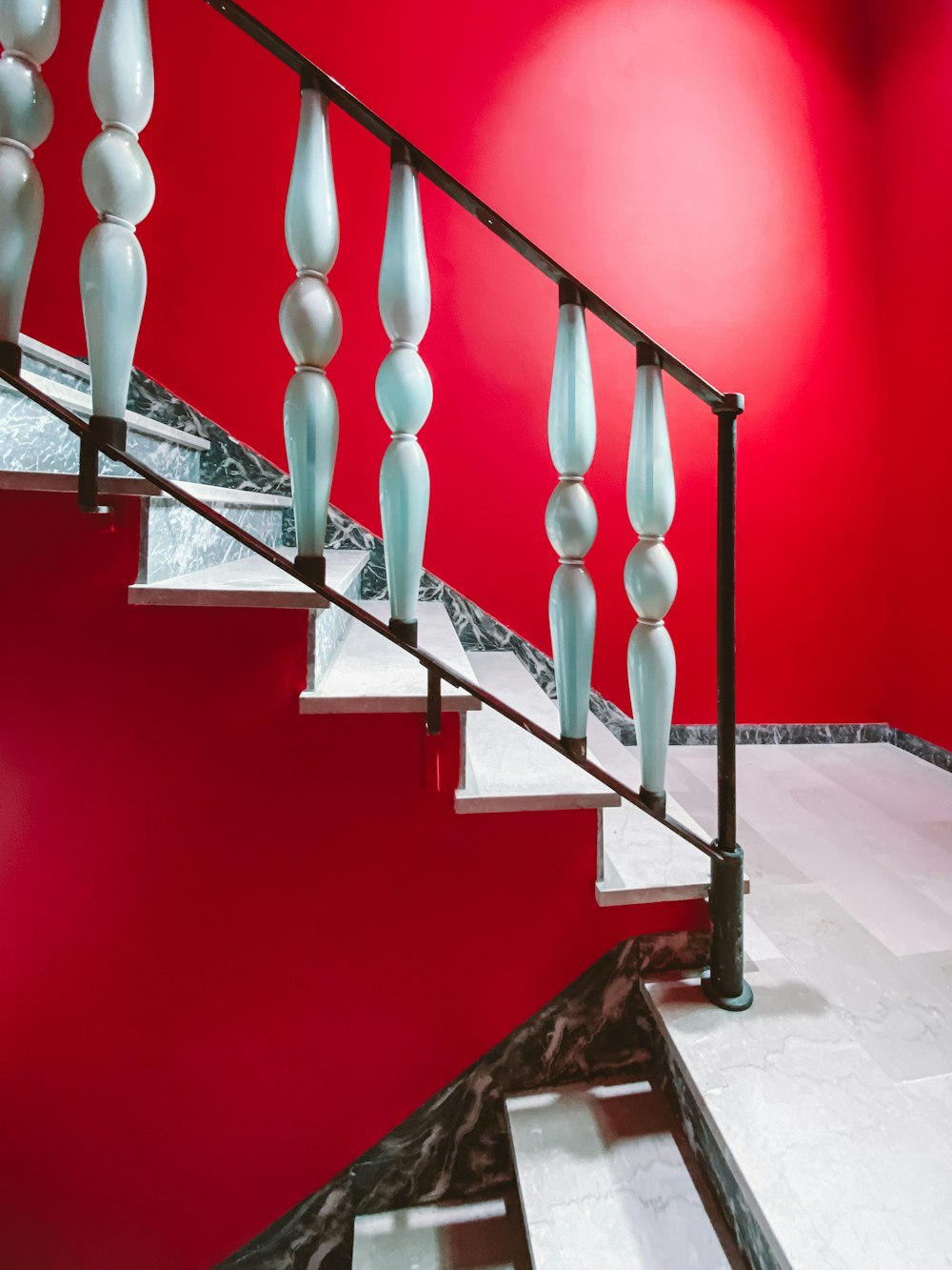 schwarze Metalltreppe mit roter Wand