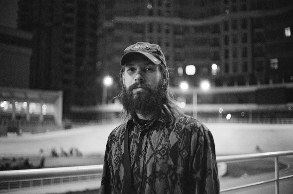 a man with a beard standing in front of a building