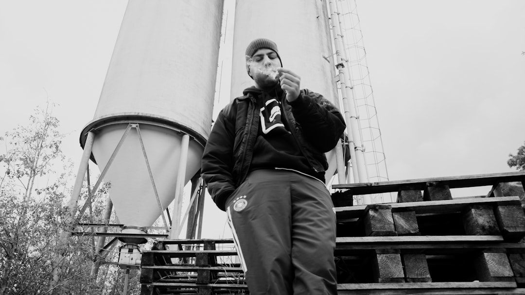 man in black jacket sitting on metal bar