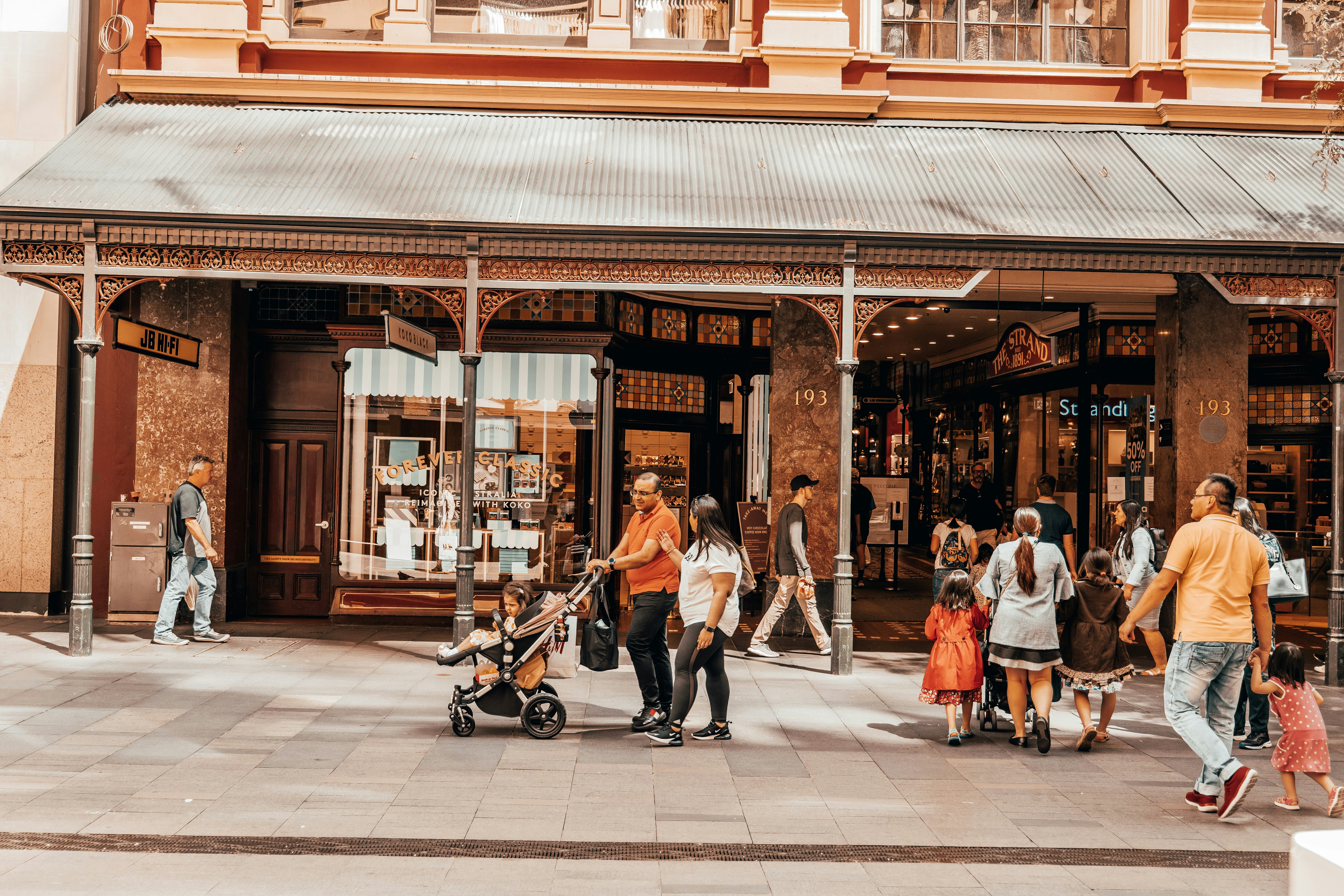 a group of people walking in front of a store