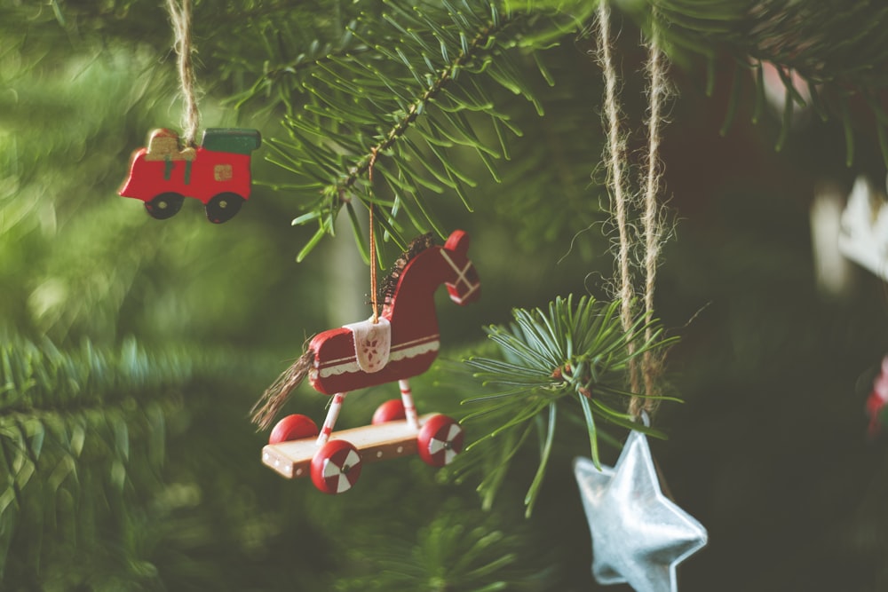 red and white plastic toy on green pine tree