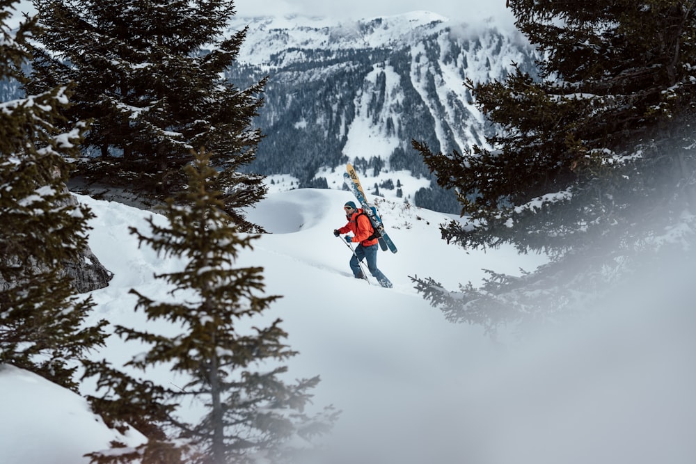 person in red jacket and black pants riding on snowboard on snow covered mountain during daytime