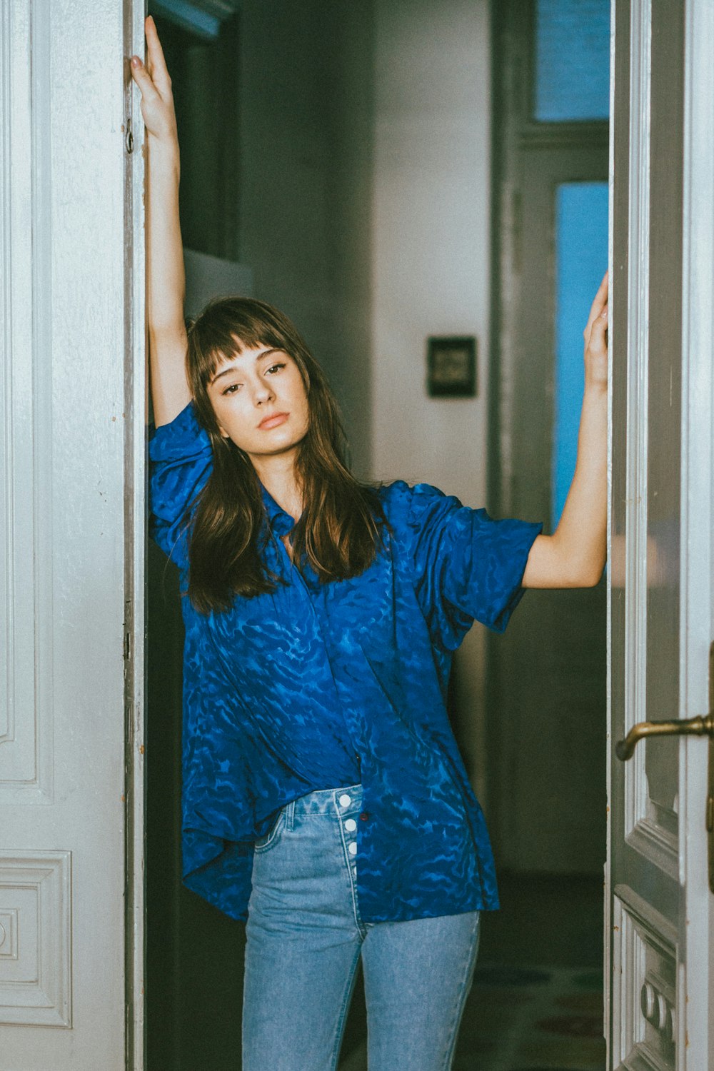 woman in blue long sleeve dress standing near door