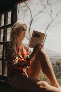 Reader in orange and black dress reading mystery fiction.