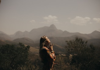 woman in black jacket standing on green grass field during daytime