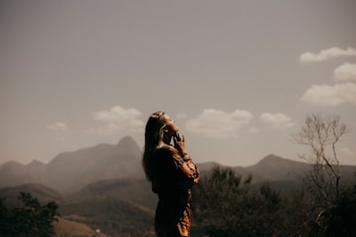 woman in black jacket standing on green grass field during daytime divine teams background