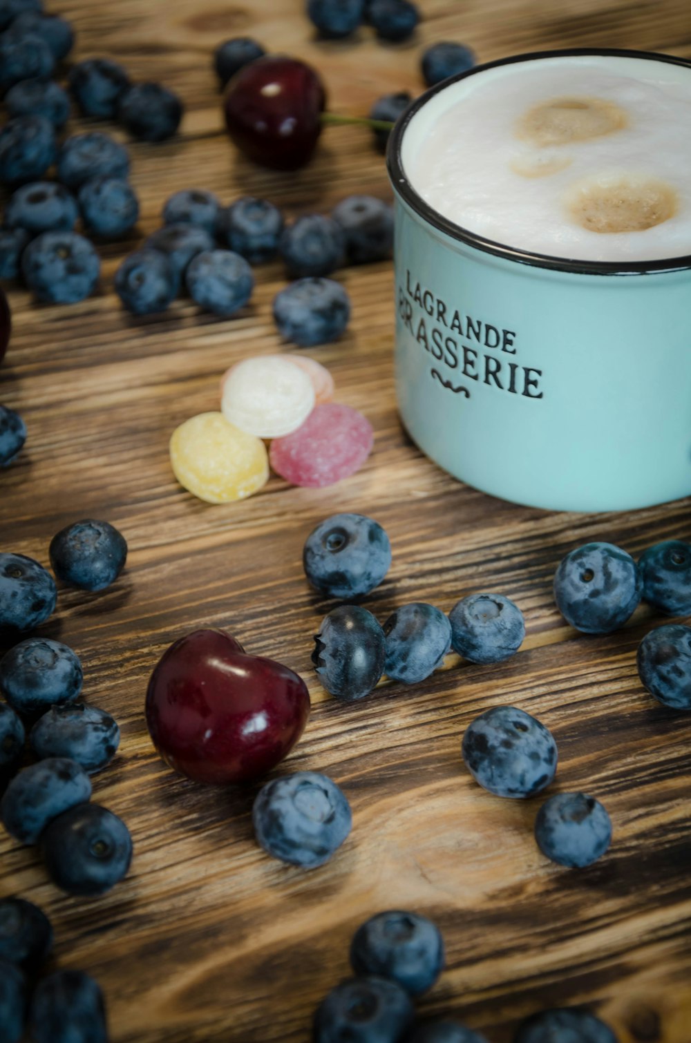 white ceramic mug beside blue stones on brown wooden table