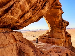 person standing on rock formation during daytime