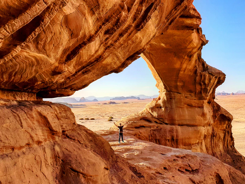 A traveller on a rock arch in Wadi Rum